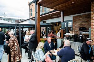 a group of people standing outside of a restaurant at Hotel Australasia in Eden