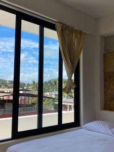 een slaapkamer met een groot raam met uitzicht bij Kavali in Los Ayala