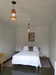 a bedroom with a white bed and two lights at Casa das Quatro Estações - Lapinha da Serra in Santana do Riacho
