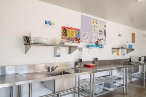uma cozinha com lavatórios e prateleiras de aço inoxidável em BIG4 Perth Midland Tourist Park em Middle Swan