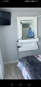 a bedroom with a bed with a mirror and a tv at Ocean room @ 66 Fynbos in Mossel Bay