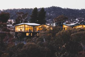 a house on top of a hill with glass at Kunama Townhouses in Jindabyne
