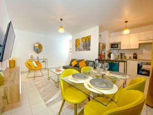 - un salon avec une table et des chaises jaunes dans l'établissement The Golden House * Parking * Garden, à Corbeil-Essonnes