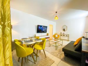 - un salon avec une table et des chaises jaunes dans l'établissement The Golden House * Parking * Garden, à Corbeil-Essonnes