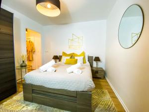 - une chambre avec un grand lit et des oreillers jaunes dans l'établissement The Golden House * Parking * Garden, à Corbeil-Essonnes