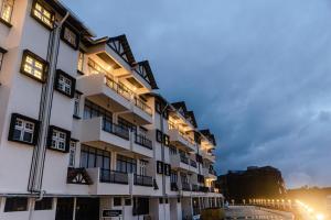 een groot wit gebouw met verlichting aan bij SPRINGHILL RESORT in Cameron Highlands