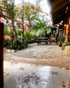un patio con panchina e un mucchio di piante di Champalao The Villa a Vang Vieng