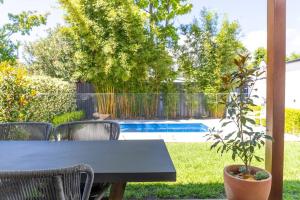 a table and chairs in a yard with a pool at The Cottage on Market in Mudgee