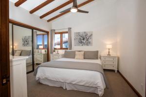 ein Schlafzimmer mit großem Bett und ein Badezimmer in der Unterkunft Premium Ocean Corner Unit, Fireplace, Golf Cart, 21 Steps from Top in Avalon