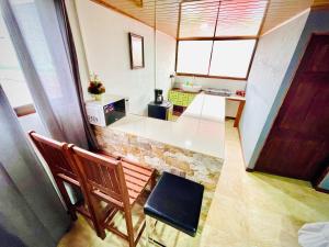 a room with a kitchen with a bench and a counter at Apart Hotel Gufo La Fortuna, Arenal Volcano in Fortuna