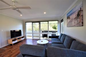 a living room with a couch and a tv at Esplanade Sophistication Close To Town And Inlet Beach in Inverloch
