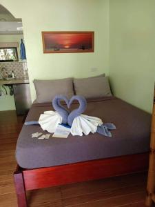 ein Bett mit zwei herzförmigen Handtüchern in der Unterkunft The Three Shooting Stars in Panglao