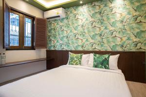 a bedroom with a large white bed and a floral wall at FOODOTEL in Bangkok