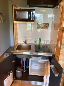 a small kitchen with a sink and a microwave at はるの空 in Biei