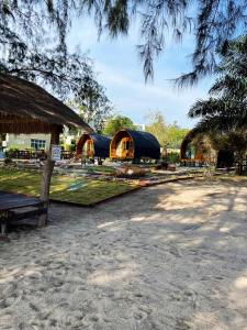 een groep gebouwen met een gebouw met een boom bij Mumsa Beach Resort & Restaurant in Ban Huai Yang