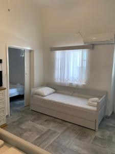 a small bedroom with a bed and a window at Myroviglia Ysternia in Istérnia