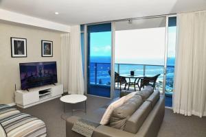 a living room with a couch and a flat screen tv at Spectacular 19th Floor Apartment in Heart of Surfers Paradise in Gold Coast