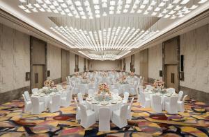 a large banquet hall with white tables and white chairs at MGM Shanghai West Bund in Shanghai