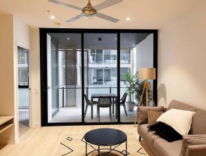 a living room with a ceiling fan and a table at New Modern apartment next to Westfield Chermside in Brisbane