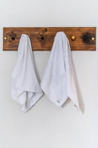 a pair of towels hanging on a wooden rail at Magnifique villa créole VILLA TI BOUT BOIS avec cheminée au tevelave in Les Avirons