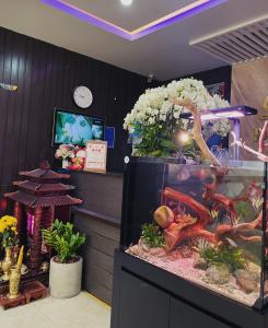 een aquarium in een kamer met bloemen bij DT Hotel Hai Phong in Hai Phong