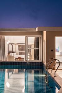 una piscina de hotel con un dormitorio en el fondo en Rainforest Woods, Assagao, Goa - Luxury 4 BHK Private Rooftop Pool en Assagao