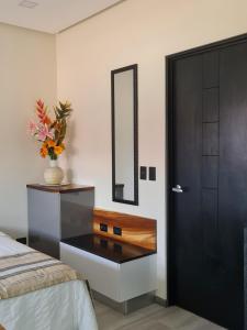 a bedroom with a black door and a vase with flowers at Cute Escazú Loft -Great view- in Escazu