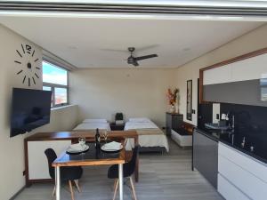 a kitchen and living room with a table and a bed at Cute Escazú Loft -Great view- in Escazu