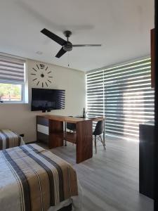 a bedroom with a desk and a clock on the wall at Cute Escazú Loft -Great view- in Escazu