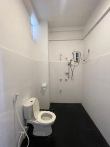 a bathroom with a white toilet in a room at Sunray Beach House in Tangalle