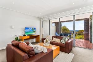 a living room with two couches and a television at Bayvista at Silverwater in San Remo