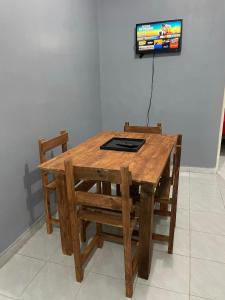 einen Holztisch mit Stühlen und einen TV an der Wand in der Unterkunft Departamento Altamira Zona Industrial (Canarios residencial) in Altamira