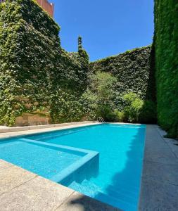 una gran piscina azul junto a una pared en Departamento con terraza, parrilla y piscina en Buenos Aires