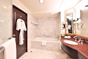 a bathroom with a tub and a sink and a bath tub at Swissotel Bangkok Ratchada in Bangkok