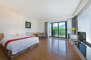 um quarto com uma cama e uma televisão num quarto em Naruwan Galaxy Hotel em Taitung City