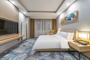 una camera con un grande letto e una TV a schermo piatto di Joy Fall Hotel a Jiaoxian