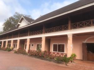 a large white building with a black roof at BKC Villa 2 in Pakbeng