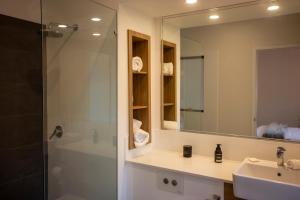 a bathroom with a shower and a sink and a mirror at The WABi Cabin - Perfect Couples Retreat in Wilyabrup