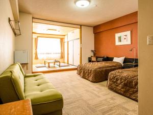 a hotel room with two beds and a couch at Kurohime Rising Sun Hotel in Shinano