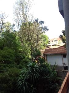 a view of a garden with trees and a house at Smarts residence in Nairobi