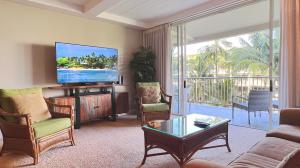 sala de estar con TV de pantalla plana y sofá en Maui Westside Presents: Whaler 420 - Best location in Kaanapali beach, en Lahaina