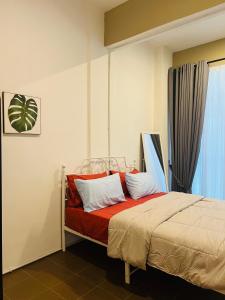 a bedroom with a bed with red sheets and white pillows at Pillow Home Town City in Kuala Terengganu