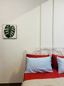 a bedroom with a bed with red and white pillows at Pillow Home Town City in Kuala Terengganu