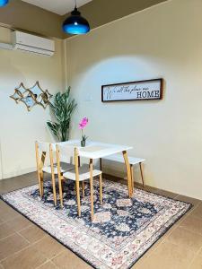 a dining room table and chairs on a rug at Pillow Home Town City in Kuala Terengganu