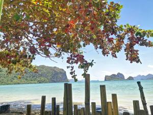a wooden fence on the beach with the ocean at El Nido Beach Camp 
