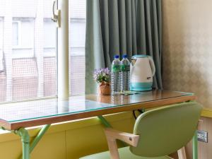 a desk in a room with a chair and water bottles at Ximenhotel-Xining西門大飯店-西寧館 in Taipei