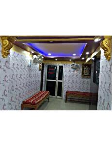 een kamer met 2 banken en een paars plafond bij Alankar Lodge, Karagpur in Kharagpur