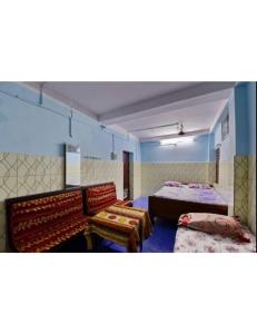 een grote kamer met 2 bedden en 2 stoelen bij Alankar Lodge, Karagpur in Kharagpur