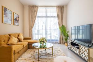 a living room with a couch and a tv at Primestay - Prime Views 1BR Meydan in Dubai
