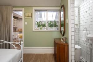uma casa de banho com um lavatório, uma janela e um espelho. em The East-Redfern Mansion on Chelsea em Sidney